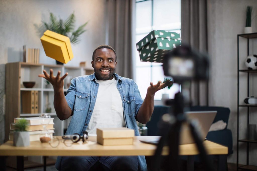 man recording video blog while unpacking presents