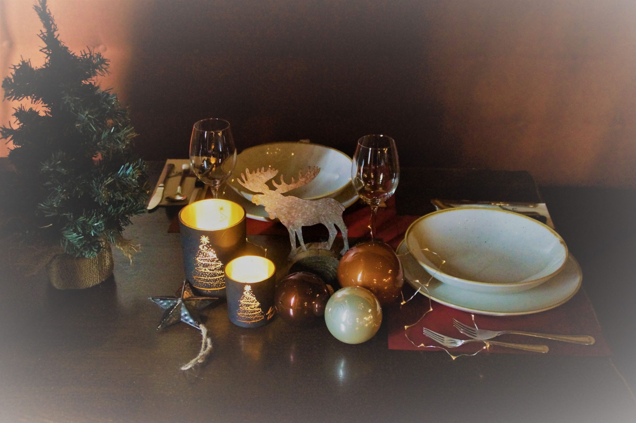 Kersttafel setting met kaarsen en decoraties.